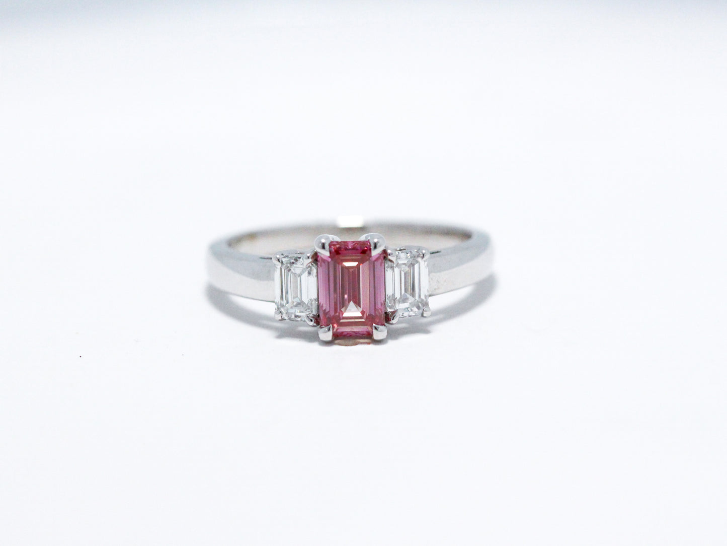 Pink emerald cut with white side stones